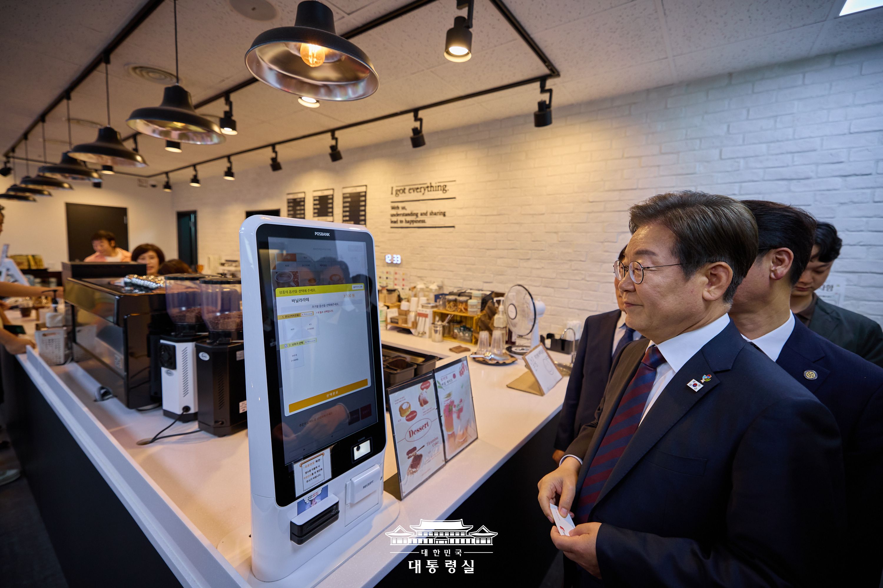 이재명 대통령이 대통령실 청사 카페 키오스크에서 음료를 주문하고 있다.